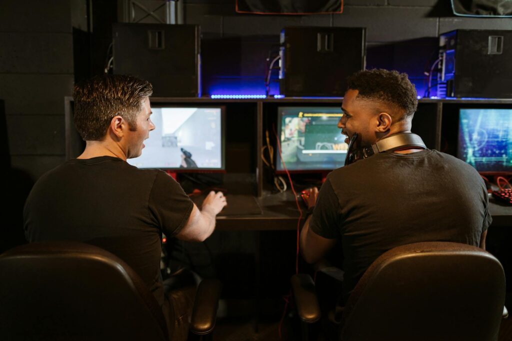 Two men engaged in an exciting gaming session in a modern cyber cafe.